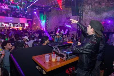 The DJ working the booth with the floor packed behind