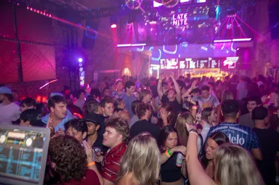 Late Nite crowd filling the floor beneath the neon sign
